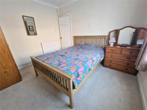 a bedroom with a bed and a dresser and a mirror at 3 Harbord road in Cromer