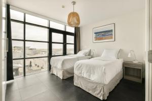 um quarto com 2 camas e uma grande janela em Appartement met zeezicht in Bloemendaal em Bloemendaal