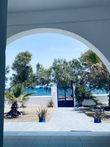 un arco con una porta blu e alcune piante di Villa 33 a Monolithos