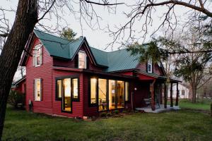 a red house with a green roof at Charming Cabin with Hot Tub & Fire Pit in Pepin