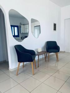 two chairs and a table in a room with a mirror at Villa 33 in Monolithos