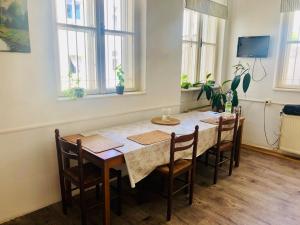 a dining room with a table with chairs and windows at Hostel Moravia Ostrava in Ostrava