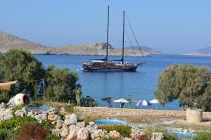 a boat in the water next to a beach at Villa Blu Majestic beach villa in Halki