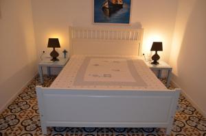 a bedroom with a white bed with two tables at Villa Blu Majestic beach villa in Halki