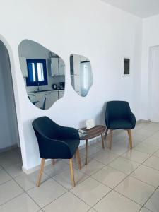um quarto com duas cadeiras, uma mesa e um espelho em Villa 33 em Monolithos