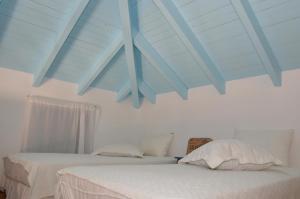 two beds in a bedroom with a blue ceiling at Villa Blu Majestic beach villa in Halki