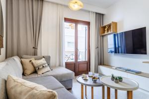 un soggiorno con divano e 2 tavoli di Potoki Apartments a Skopelos Town