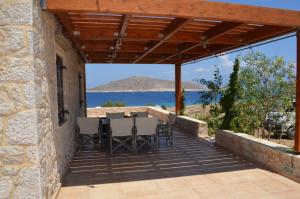 a patio with a table and chairs and a view of the ocean at Villa Blu Majestic beach villa in Halki
