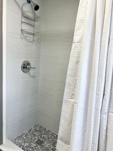 y baño con ducha y cortina de ducha. en Harmonious Suites, en North Miami Beach