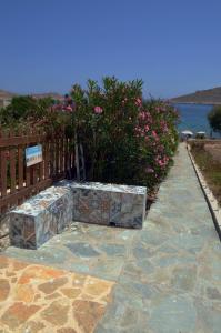 a stone bench sitting on a sidewalk next to a fence at Villa Blu Majestic beach villa in Halki