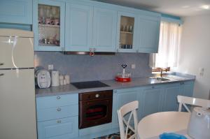 a kitchen with blue cabinets and a sink and a refrigerator at Villa Blu Majestic beach villa in Halki