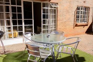 a glass table and chairs on a patio at Lovely Spacious Two bedroom apartment in Johannesburg