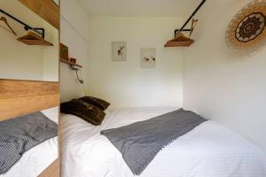 Un pat sau paturi într-o cameră la Tiny house - fietsverhuur, eigen keuken en badkamer