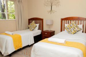 um quarto com 2 camas e uma janela em Lovely Spacious Two bedroom apartment em Joanesburgo