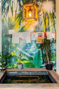 een muur met een muurschildering van palmbomen en planten bij Tiny house - fietsverhuur, eigen keuken en badkamer in Nijmegen