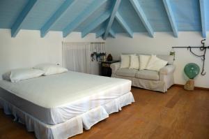 a bedroom with a large bed and a couch at Villa Blu Majestic beach villa in Halki