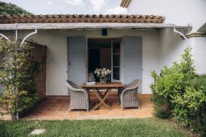 eine Terrasse mit einem Tisch und 2 Stühlen in der Unterkunft La Villa d'Andrea in Ramatuelle