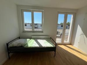 1 dormitorio con 1 cama y 2 ventanas en WPS Residenz en Frankfurt