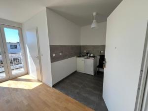 a kitchen with white walls and a large window at WPS Residenz in Frankfurt/Main