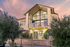 a house with large windows and a fence at Beachside Bliss 1BR Mindarie in Mindarie