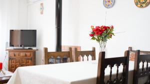 Una mesa blanca con un jarrón de flores. en Casa Uly en Riumar