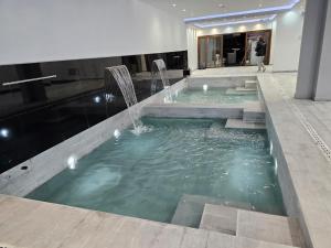 a swimming pool with a fountain in a building at Suite La Posta in San Salvador de Jujuy +44 photos
