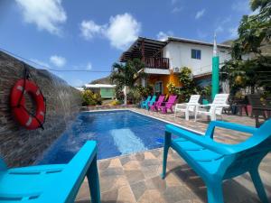 una piscina con sillas azules y una piscina en Posada Ashanty, en Providencia