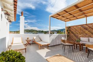 un patio con sedie, tavoli e un faro di Potoki Apartments a Skopelos Town