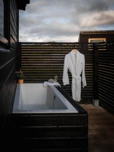 a robe hanging on a wall next to a bath tub at Wild Hideaways Luxury Lodges and Eco Spa in Bantry