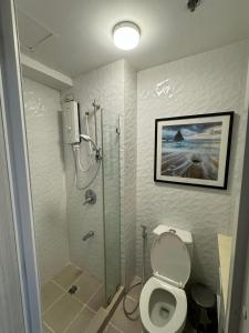 a bathroom with a shower and a toilet and a sink at Smdc wind residences in Kaybagal
