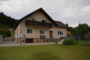 ein Haus mit einem Kind, das davor steht in der Unterkunft Urlaubsnest in Harbach