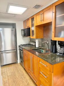 a kitchen with wooden cabinets and a stainless steel refrigerator at Harmonious Suites in North Miami Beach