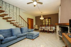 Stay Barcelona Villa Miami في ميامي بلاتجا: غرفة معيشة مع أريكة زرقاء ومدفأة