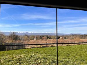 una vista da una finestra di un campo e delle montagne di Climb cottage a Komarno Altre 2 foto