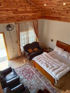 una camera con un grande letto e un divano di The Kunhar Beach Cottage By Country Club Balakot a Bālākot