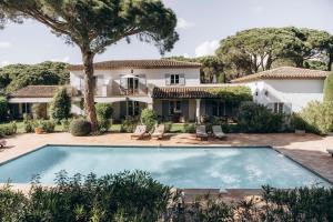 an exterior view of a house with a swimming pool at La Villa d'Andrea in Ramatuelle