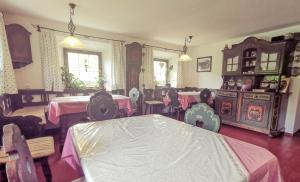 ein Esszimmer mit Tischen und Stühlen sowie einem rosa Tischtuch in der Unterkunft Pension Wagnerhof in Oberaudorf