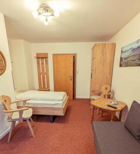a room with a bed and a table and chairs at Pension Wagnerhof in Oberaudorf