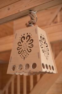 a wooden light fixture hanging from a ceiling at Domek u Hanci z balia na wyłączność in Ząb