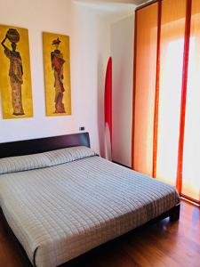 1 dormitorio con 1 cama y 2 cuadros en la pared en Appartamento sulla Riviera del Conero, en Numana