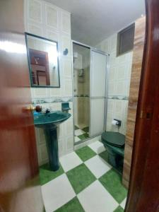 ein Badezimmer mit grünem WC und Waschbecken in der Unterkunft Amplia Casa Familiar in Bogotá