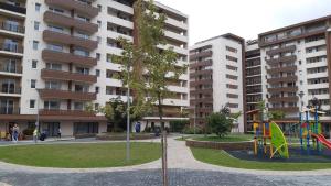 a playground in a park with tall buildings at Apartament Marcel - Coresi Mall in Braşov