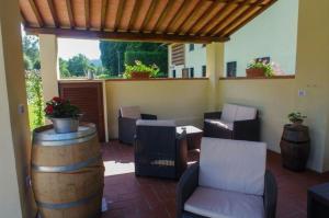 eine Terrasse mit einem Zimmer mit Stühlen und einem Fass in der Unterkunft Ferienhaus für 27 Personen in Monsagrati, Toskana Provinz Lucca in Monsagrati