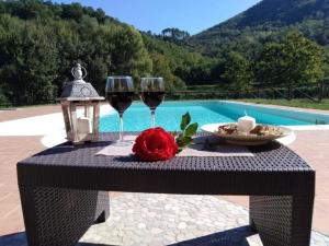 una mesa con dos copas de vino y una vela en Ferienhaus mit Privatpool für 27 Personen ca 346 qm in Monsagrati, Toskana Provinz Lucca, en Monsagrati