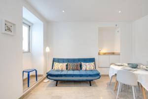 a living room with a blue couch and a table at Rio Pearl 45 in Trafaria
