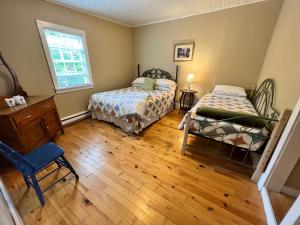 1 Schlafzimmer mit 2 Betten und einem Fenster in der Unterkunft Bishop White Manor in Trinity