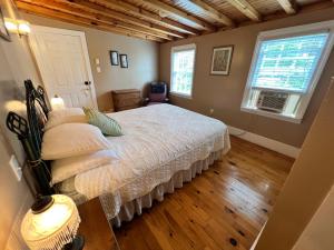 ein Schlafzimmer mit einem Bett und zwei Fenstern in der Unterkunft Bishop White Manor in Trinity