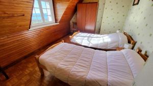 Plozévet697-Villa Hent Kost la mer a 10m的带木镶板的房间里有两张床