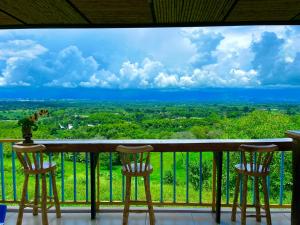 a balcony with two chairs and a view at Finca Hotel Mirador La Casona Quindio-Eje Cafetero in Pueblo Tapao