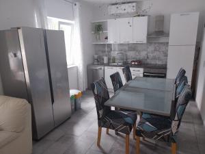 a kitchen with a table and chairs and a refrigerator at Vila Brig 108 - private swimming pool and jacuzzi in Rijeka